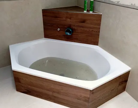 Fertige Eckbadewanne mit Verkleidung in Holzoptik